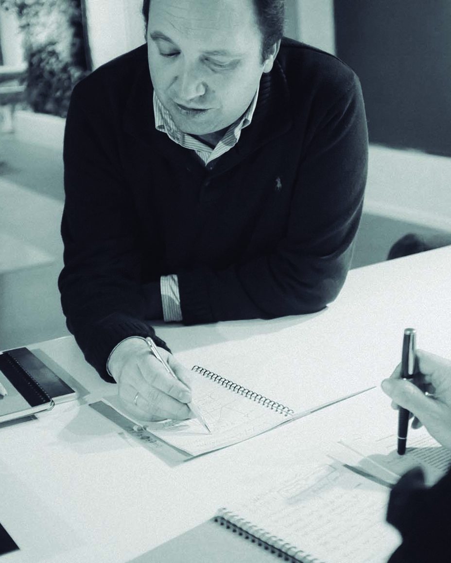 Antonio León sketching a formulation at a worktable