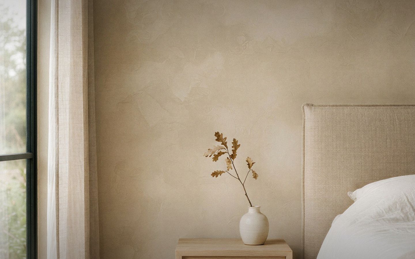 A limewashed bedroom wall in soft morning light